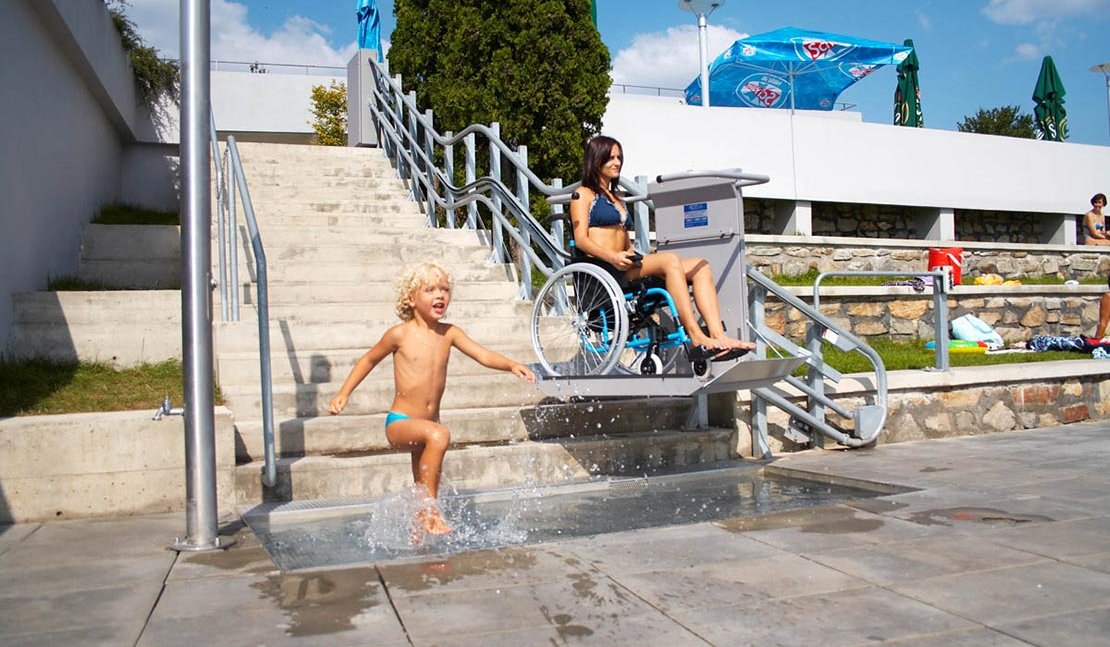 Eine junge Dame benutzt mit ihrem Rollstuhl den Plattformtreppenlift OMEGA im Außenbereich